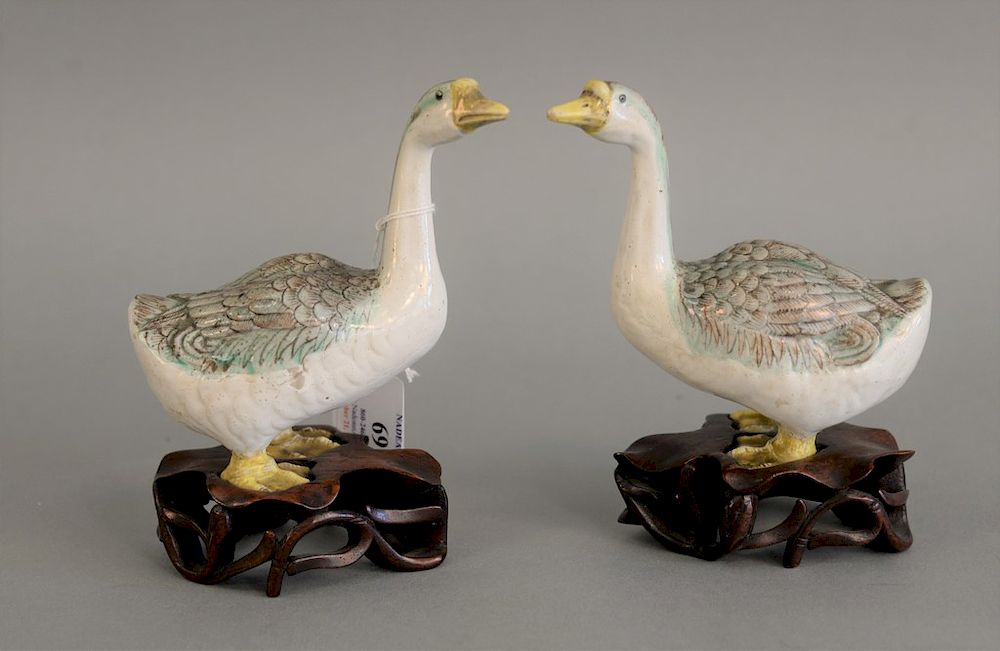 Appraisal: Pair of Chinese porcelain models of geese on carved lily