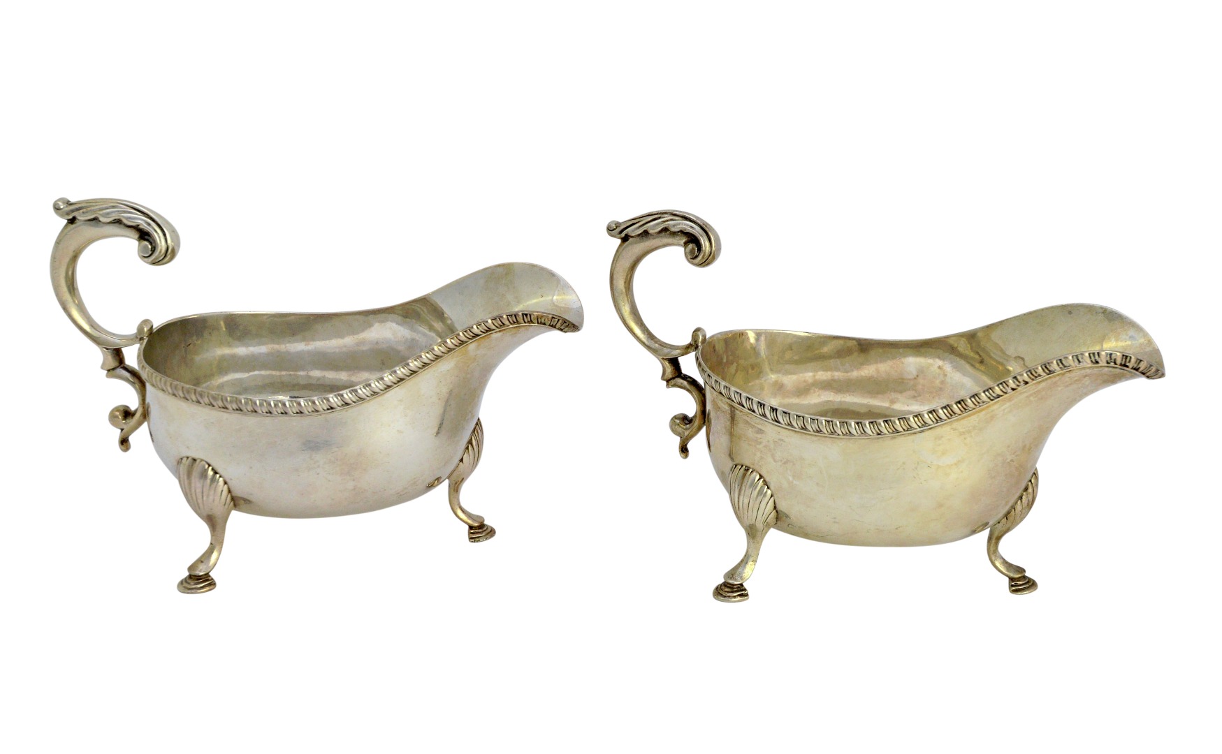 Appraisal: A pair of silver sauceboats each with a scrolling handle