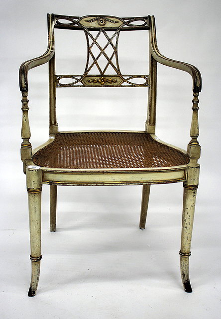 Appraisal: A CREAM AND PARCEL GILT PAINTED REGENCY OPEN ARMCHAIR with