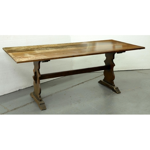 Appraisal: An oak dining table with trestle ends and pegged stretcher