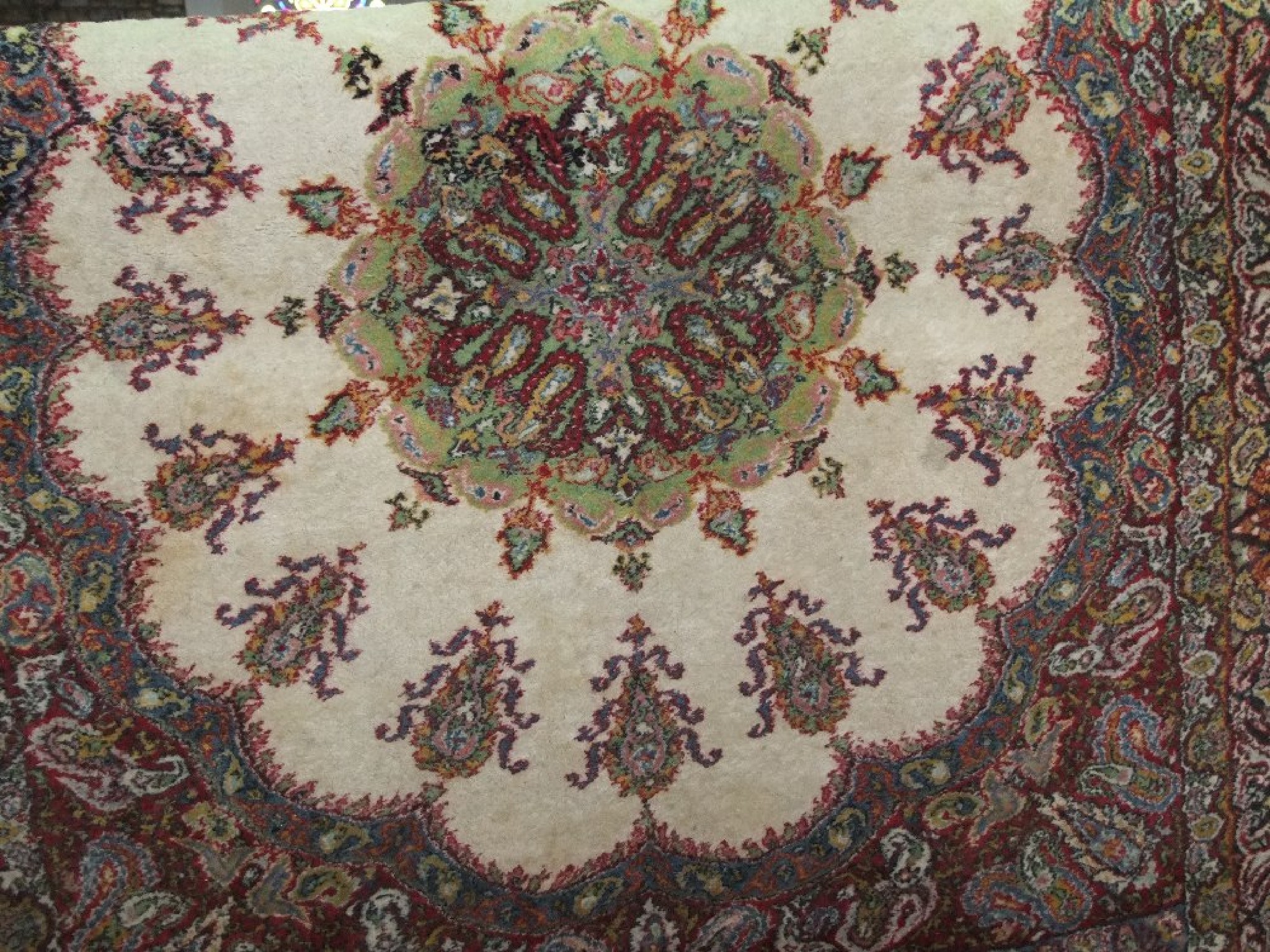 Appraisal: An eastern wool rug with white ground medallion centre set