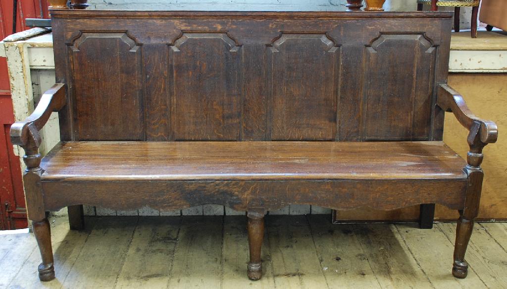 Appraisal: ANTIQUE OAK SETTLE with four arch panelled back above downswept