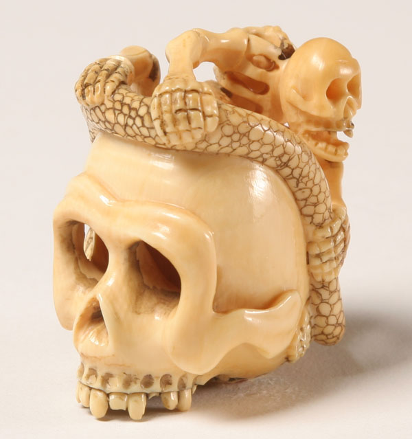 Appraisal: Japanese carved ivory netsuke a skeleton and snake peer out