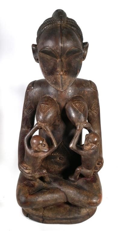 Appraisal: African carved wooden image a mother breastfeeding two children Includes