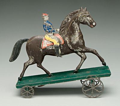 Appraisal: Tin horse and rider pull toy jocky riding horse on