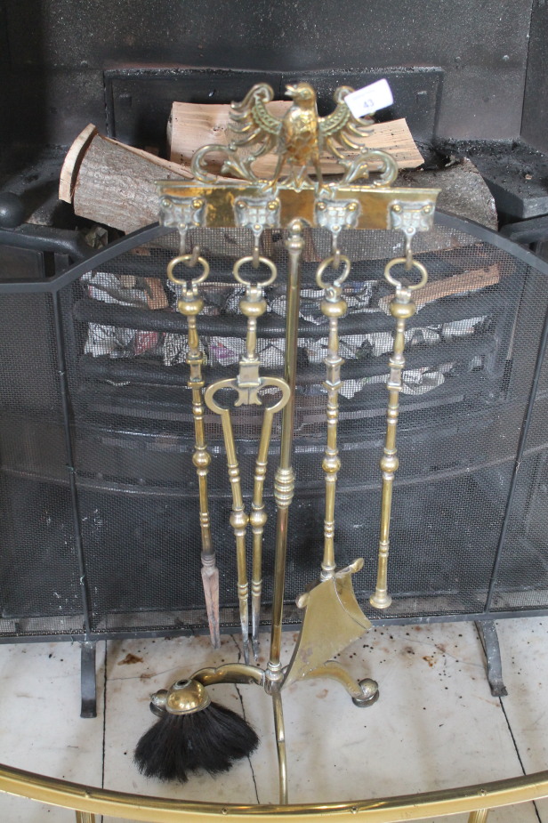 Appraisal: A brass tripod fireside companion set with tools