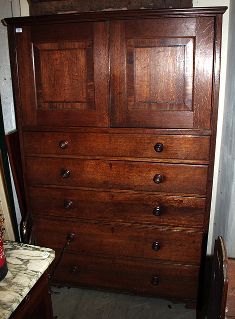 Appraisal: A TH CENTURY OAK LINEN PRESS with twin panelled cupboard