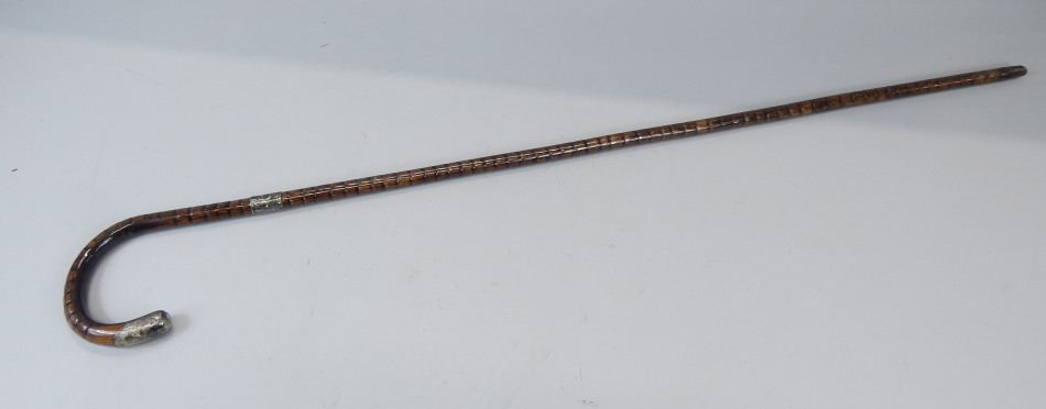 Appraisal: A walking cane with silver collar and handle