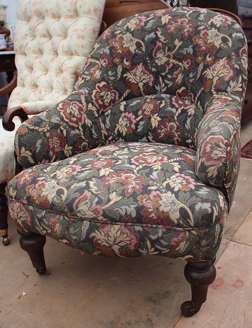 Appraisal: A VICTORIAN LOW OCCASIONAL CHAIR with shaped upholstered back arms