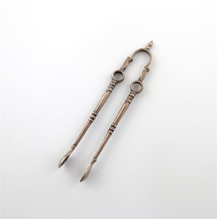 Appraisal: A pair of cast silver andiron sugar nips