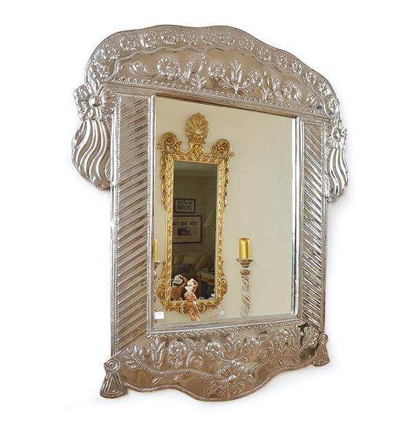 Appraisal: A PRESSED METAL MOUNTED WALL MIRROR WITH EMBOSSED FOLIATE DECORATION