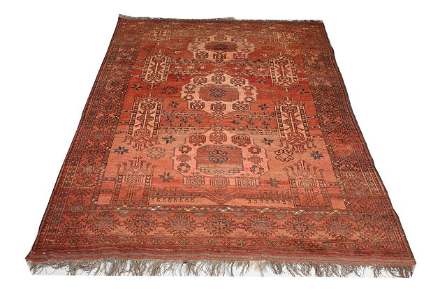 Appraisal: AN AFGHAN WINE GROUND RUG with stylised geometric designs within