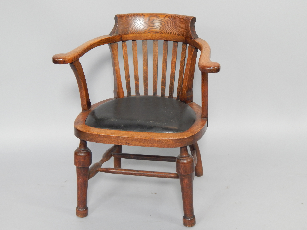 Appraisal: A thC oak captain's chair with scrolling arms leather seat