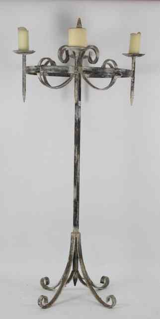 Appraisal: A wrought iron four-light candle stand with scroll decoration and