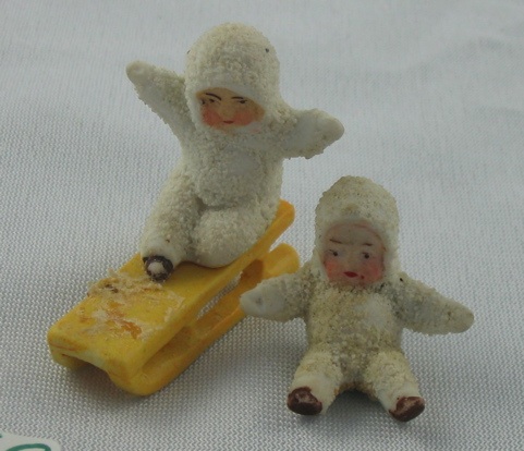 Appraisal: TWO EARLY SNOW BABIES One perched on a yellow sled