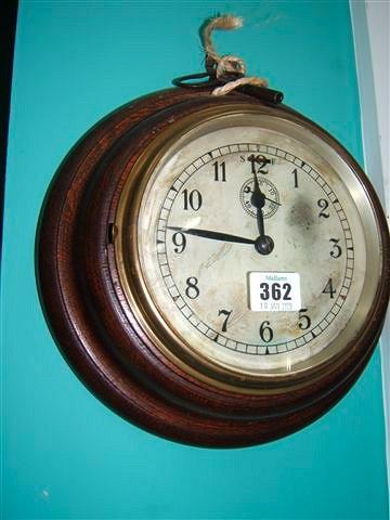 Appraisal: A turned oak ship's clock with brass bezel and silvered