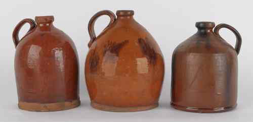 Appraisal: Three Pennsylvania redware jugs th c with manganese decoration tallest