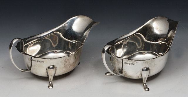 Appraisal: A PAIR OF SILVER SAUCE BOATS with wavy edges cabriole