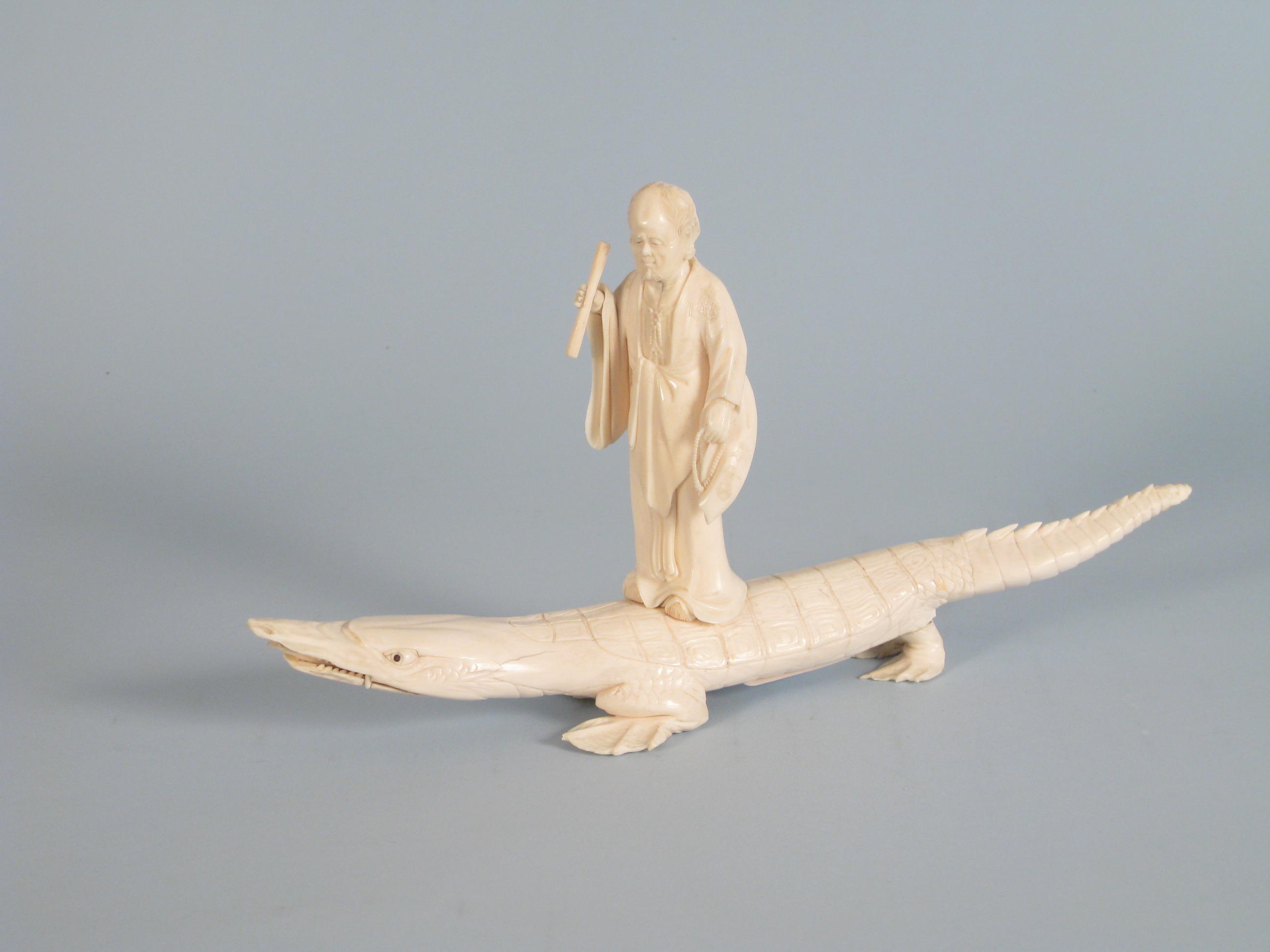 Appraisal: A carved ivory Figure standing on a crocodile in