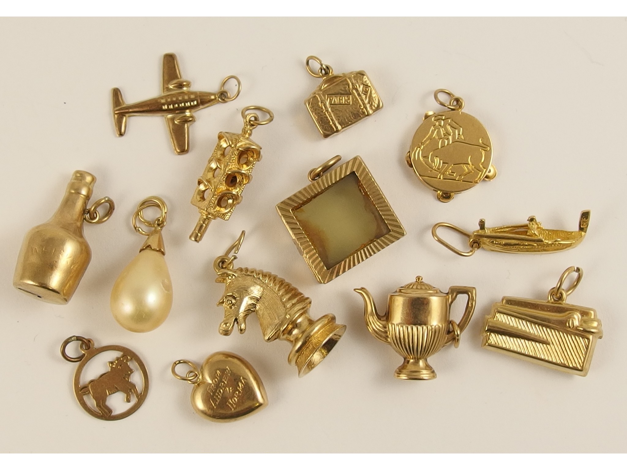 Appraisal: A collection of thirteen gold and yellow metal charms to