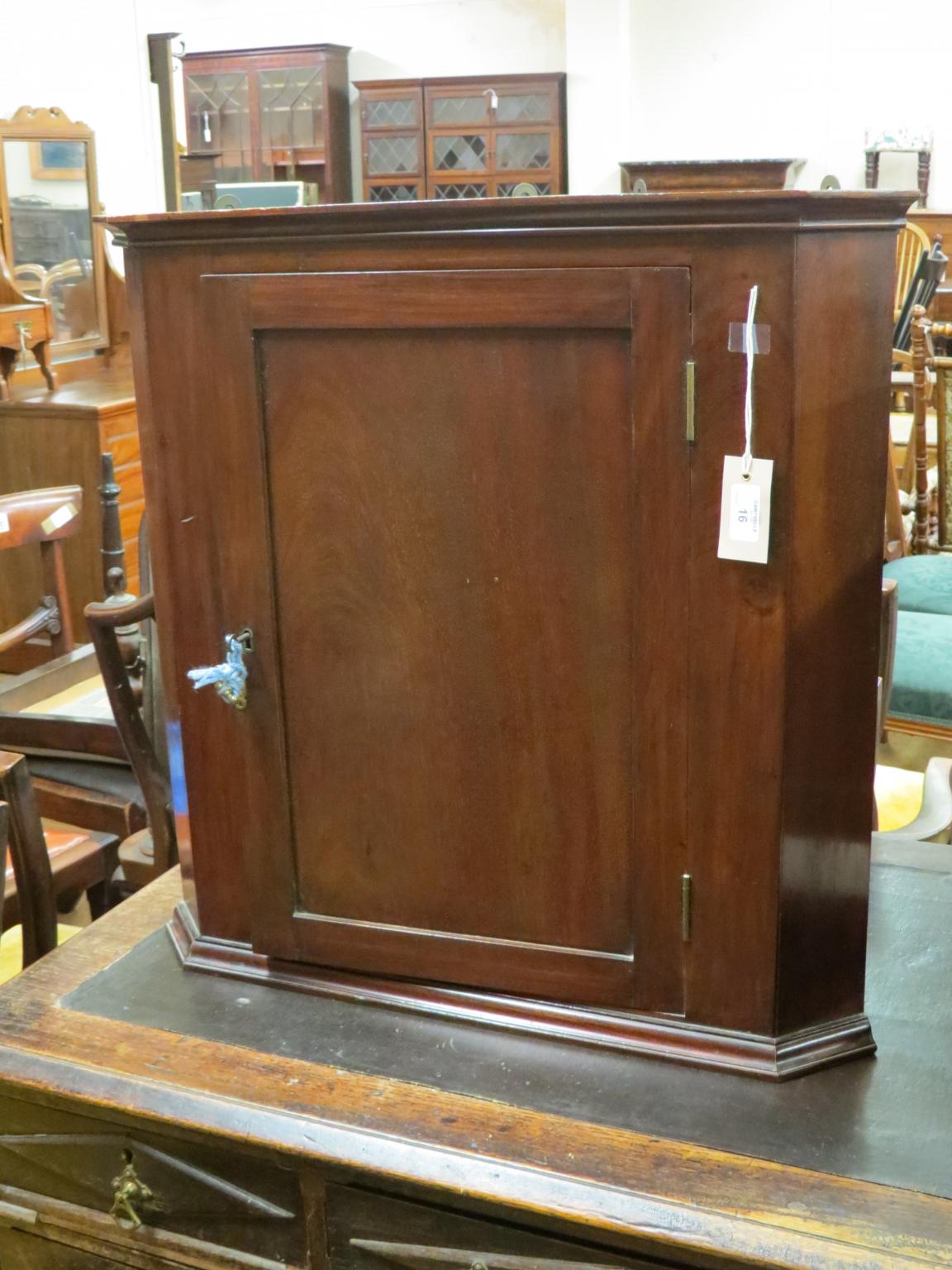 Appraisal: A Victorian solid mahogany corner cupboard single panelled door enclosing