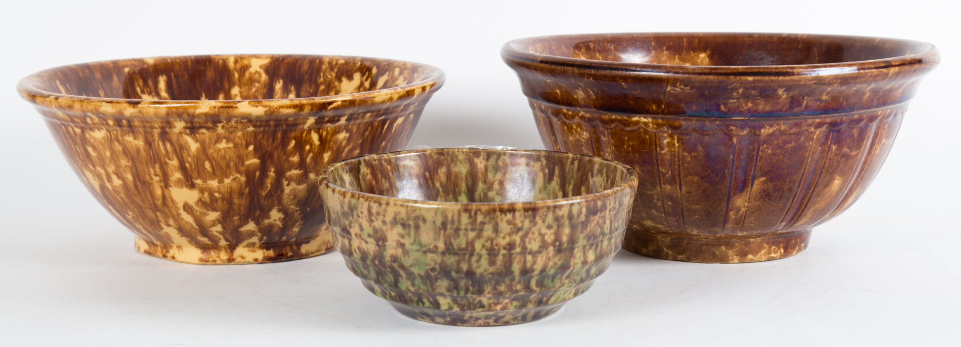 Appraisal: Three Rockingham glazed pottery bowls mid- th century each with