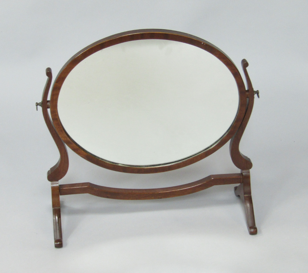 Appraisal: An Edwardian oval mahogany swing framed toilet mirror on a