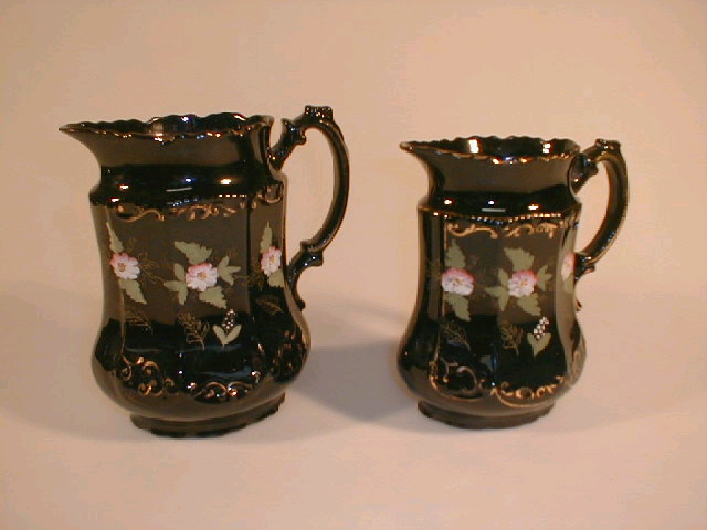 Appraisal: Two graduated Jackfield type water jugs with gilt and enamel