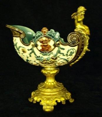 Appraisal: A majolica style cornucopia moulded a gilt metal cherub on