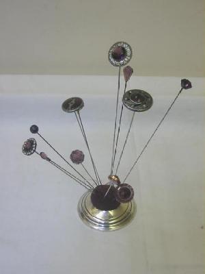 Appraisal: TWELVE PURPLE GLASS HAT PINS one with faceted centre within