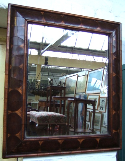 Appraisal: An oyster veneered olive wood and walnut cushion frame mirror