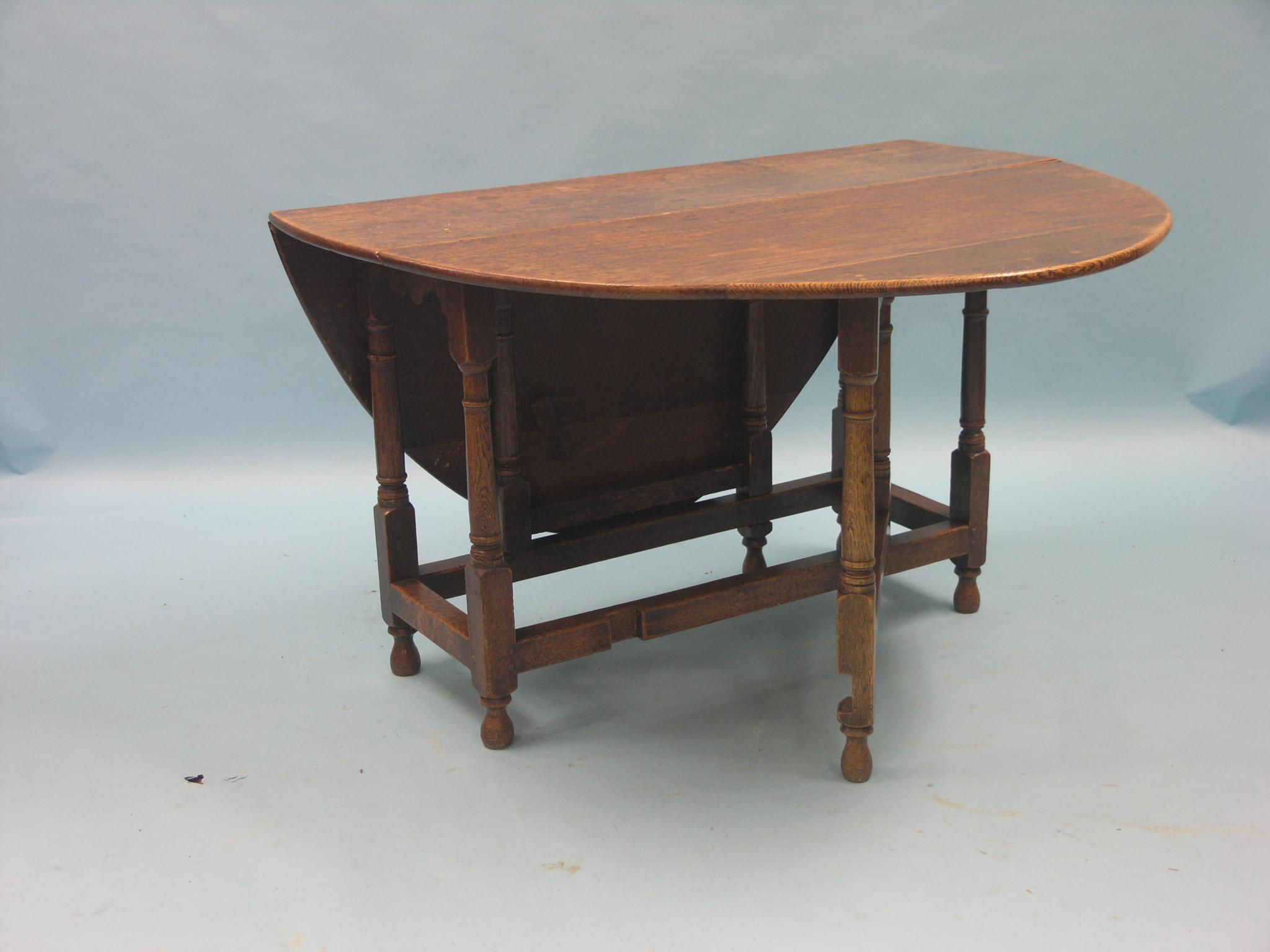 Appraisal: An th century oak gateleg dining table on baluster-turned underframe