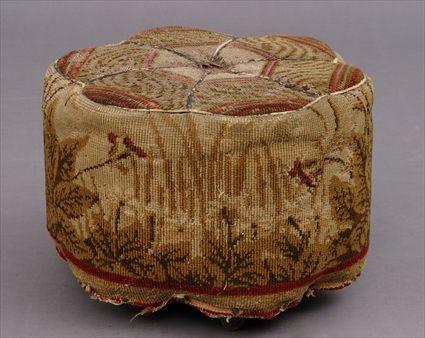 Appraisal: VICTORIAN BRUSSELS CARPET-UPHOLSTERED OTTOMAN The six-lobe top over conforming body