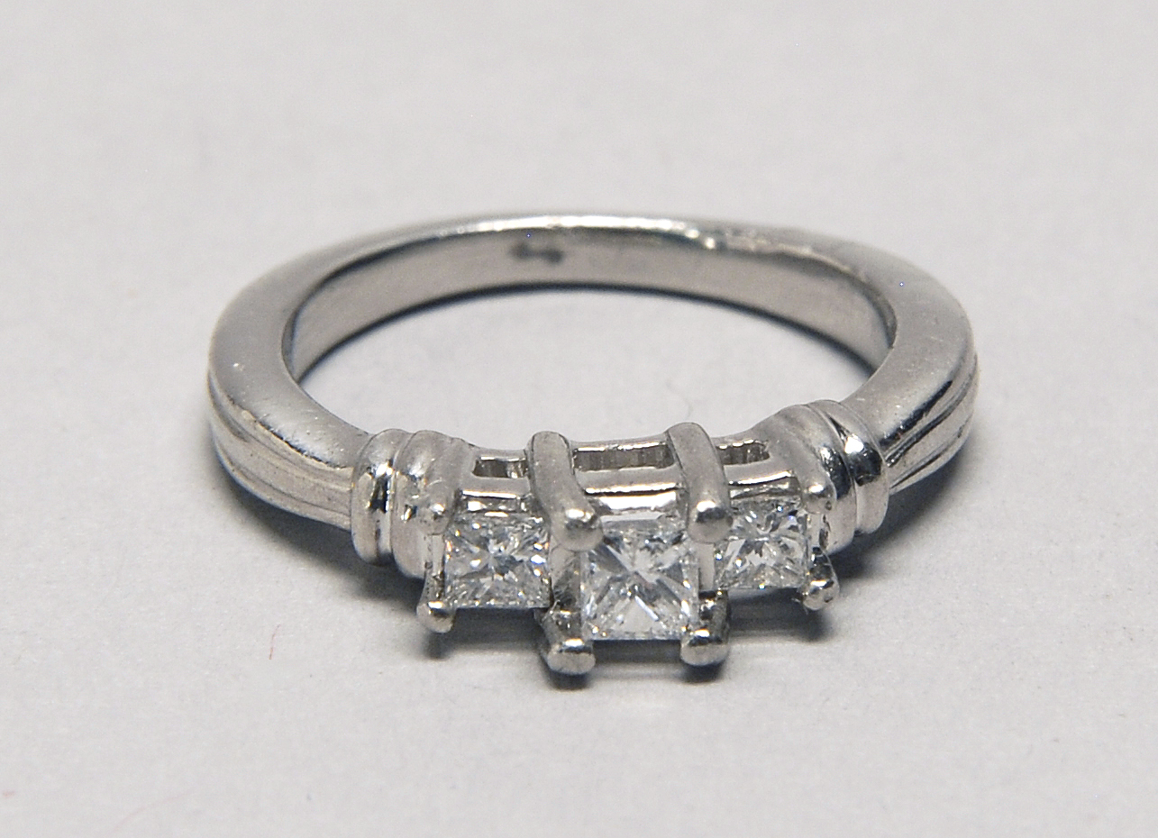 Appraisal: PLATINUM AND DIAMOND RING Central mm stone flanked by two