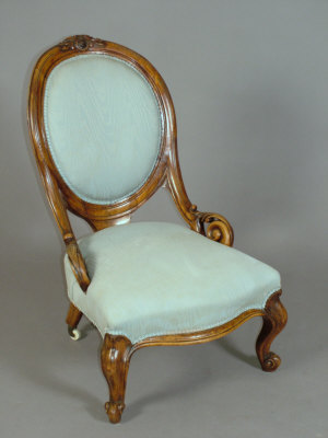 Appraisal: A Victorian walnut and line carved nursing chair with pale