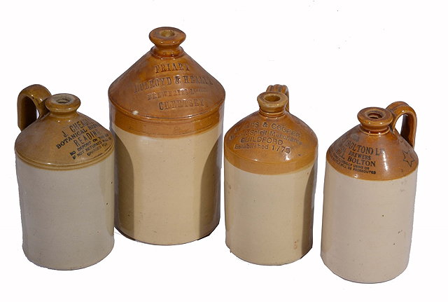 Appraisal: FOUR OLD BREWER'S POTTERY JARS with side handles largest cm