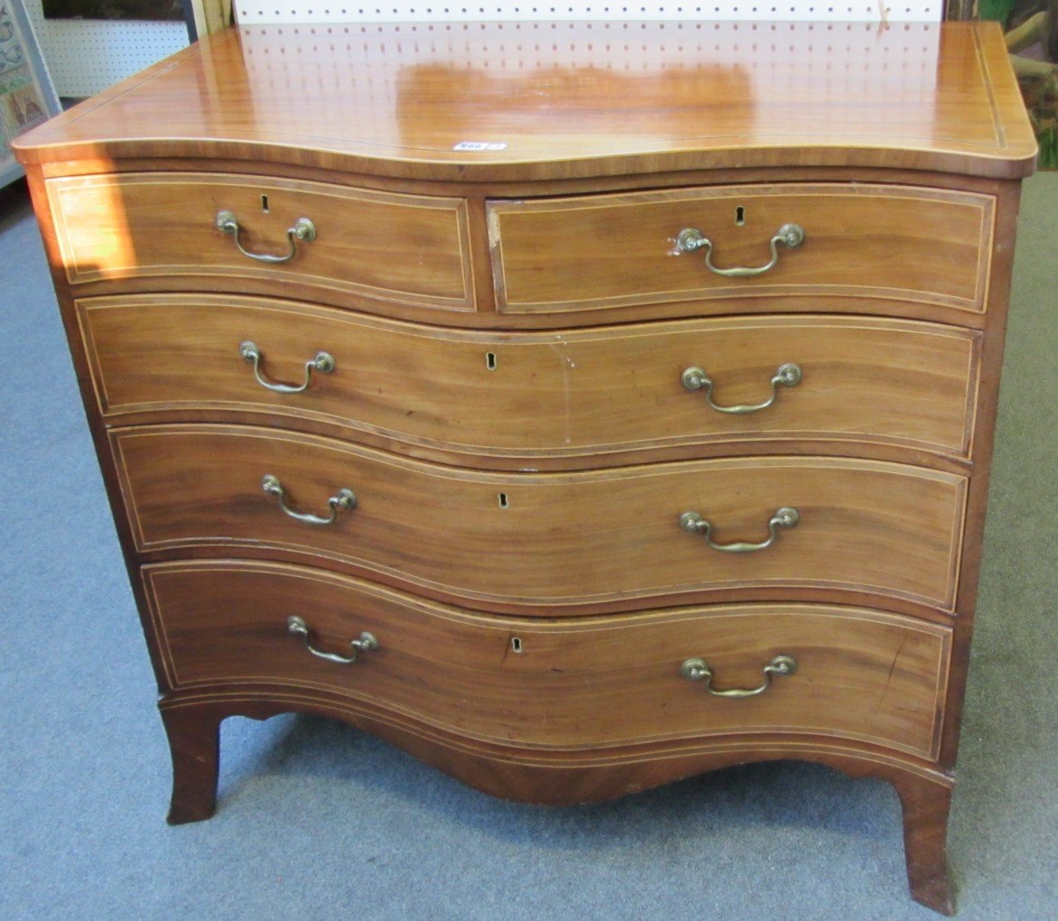 Appraisal: An inlaid George III mahogany serpentine chest of two short