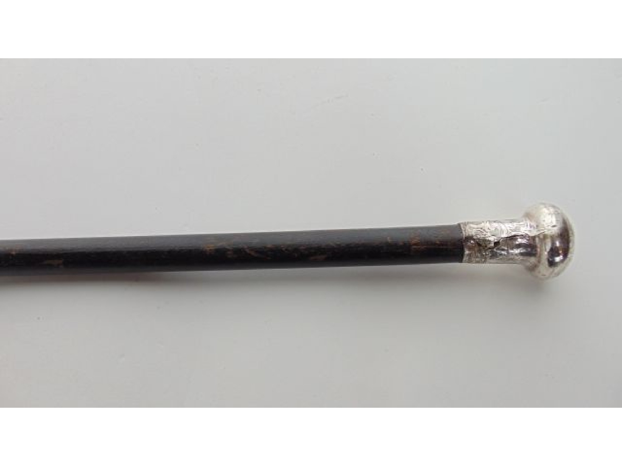 Appraisal: An ebonised walking cane terminating in a chased silver knop