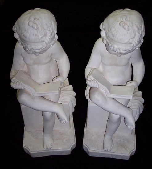 Appraisal: A pair of plaster bookends modelled as seated putti reading