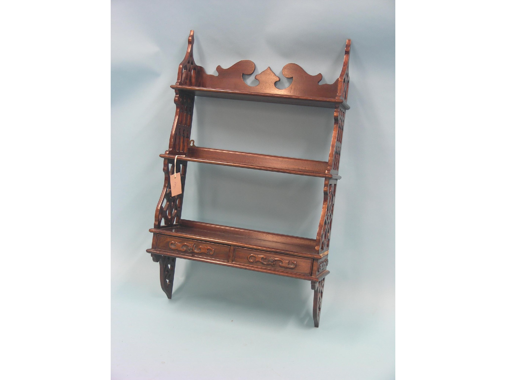 Appraisal: A Chippendale-style mahogany shelf unit three shelves and lattice-work ends