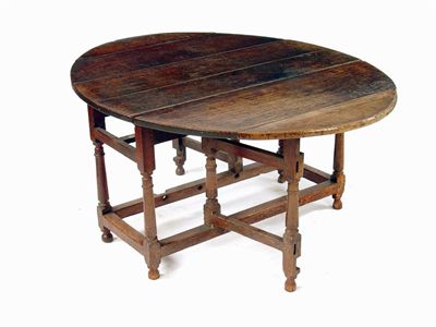 Appraisal: An oak gateleg table the boarded oval top above an