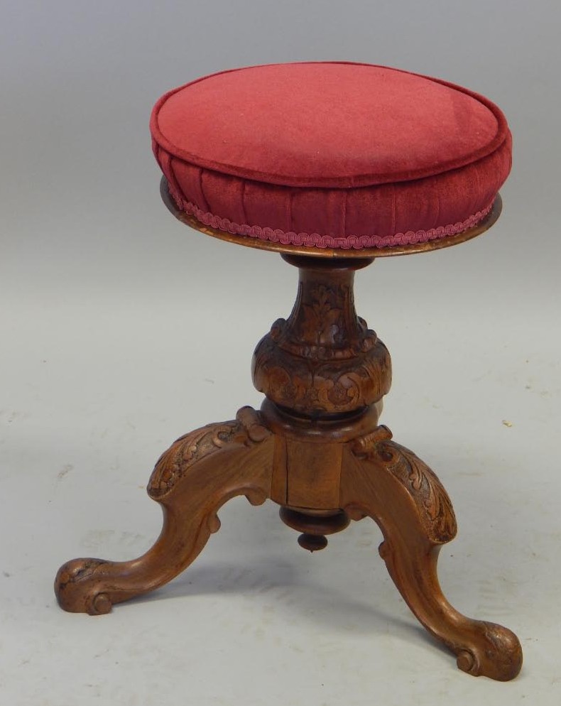 Appraisal: A Victorian walnut revolving piano stool with a padded top