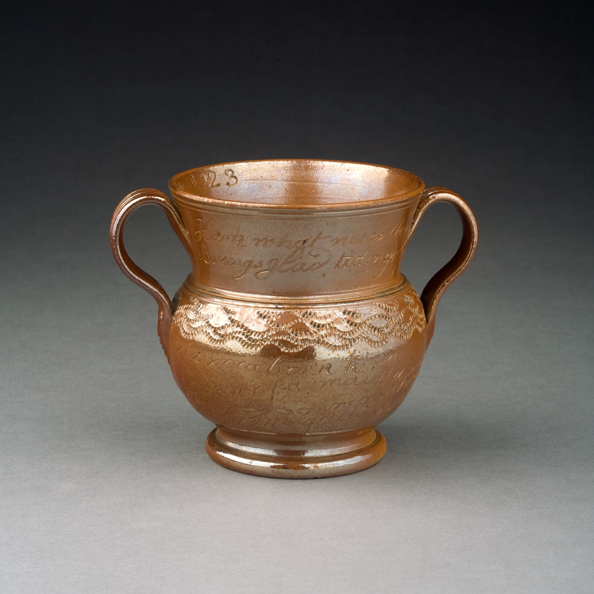 Appraisal: STAFFORDSHIRE BROWN-GLAZED EARTHENWARE TWO-HANDLED CUP DATED ' Inscribed inside the