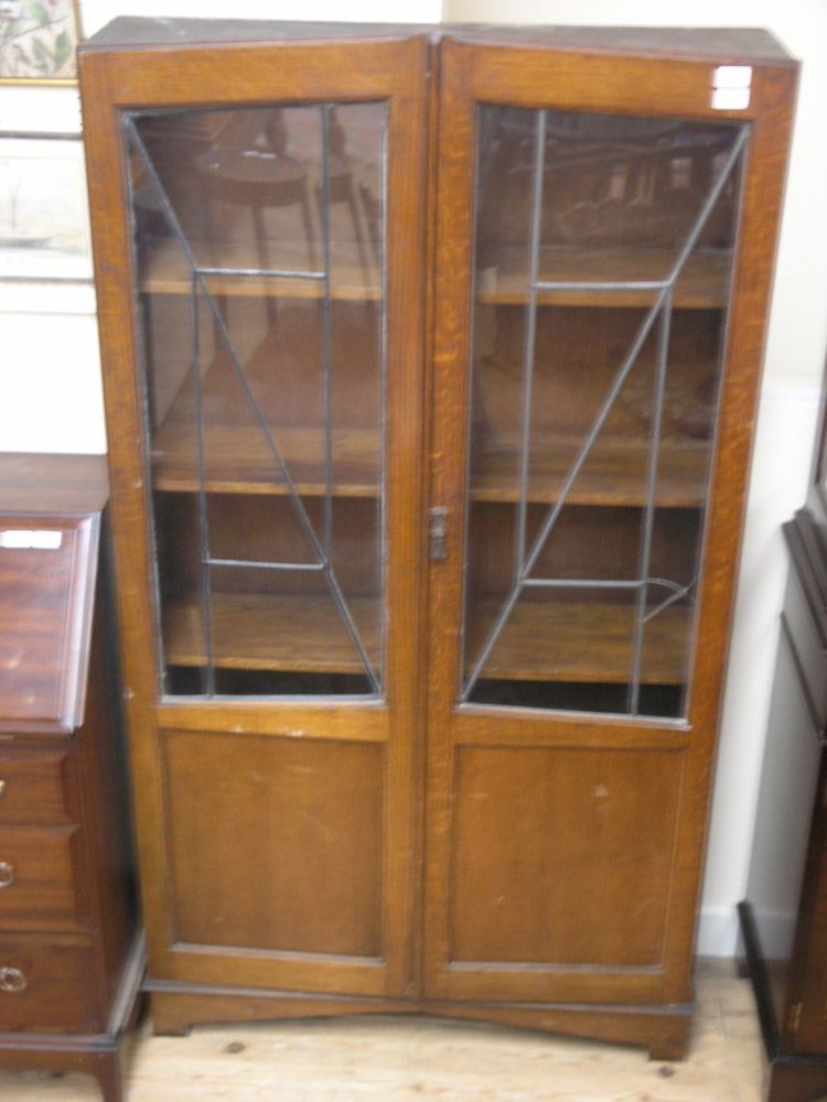 Appraisal: An early th century oak bookcase enclosed by a pair