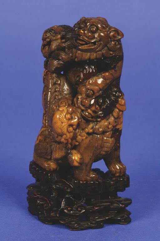 Appraisal: A CHINESE ROOT AMBER LION GROUP carved as four playful