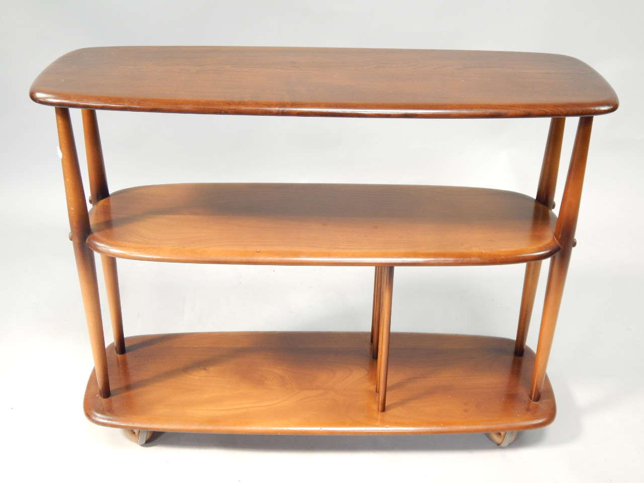 Appraisal: An Ercol elm and beech three tier stand on shepherd