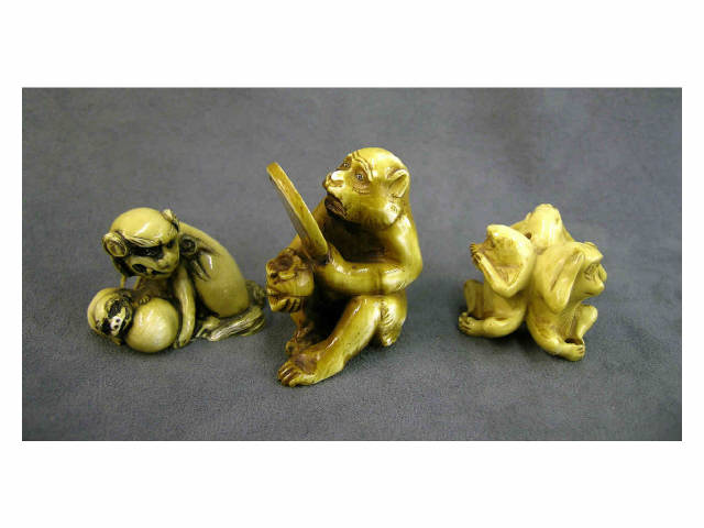 Appraisal: Three ivory netsuke animal figures including monkey looking into mirror