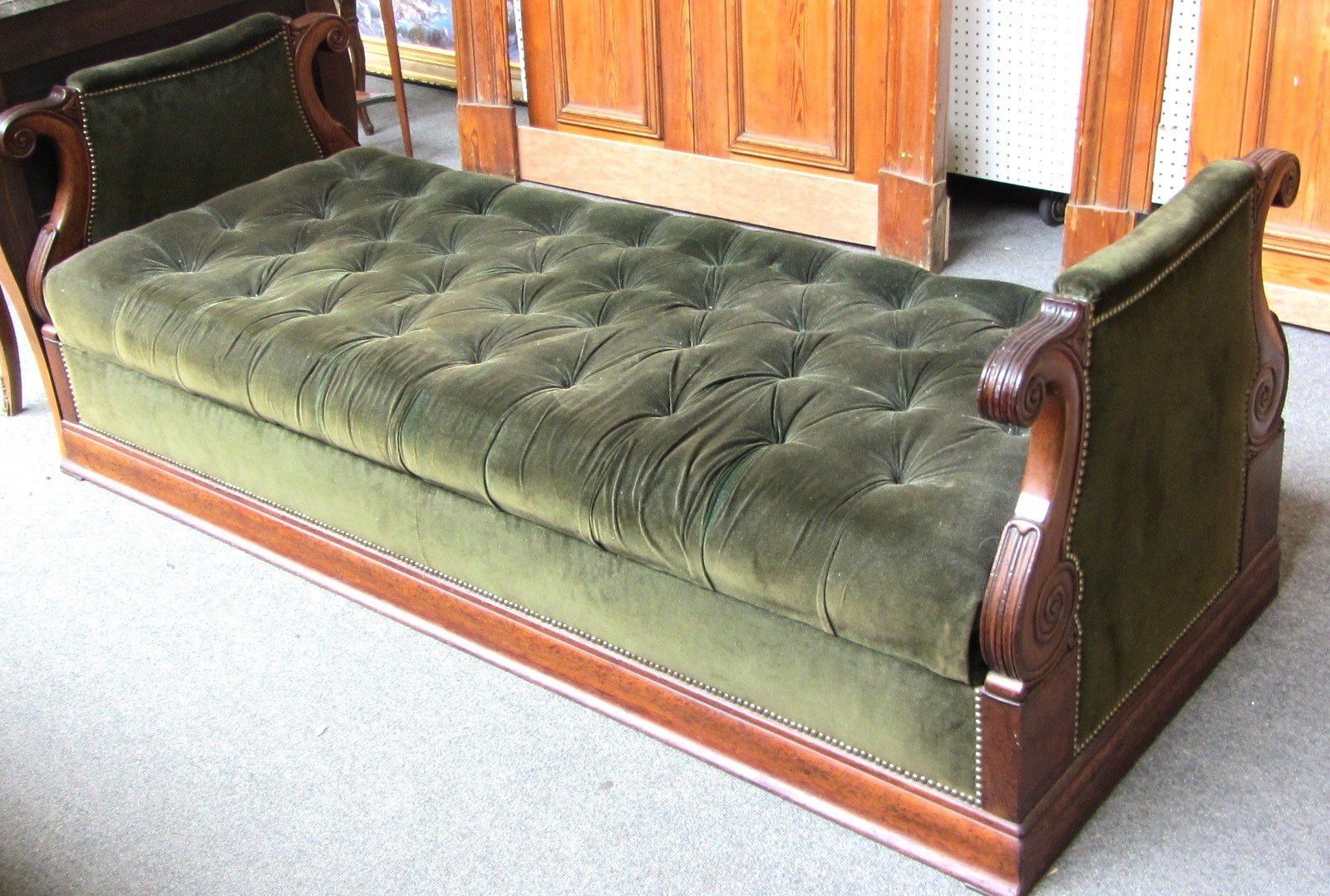 Appraisal: An Empire mahogany upholstered banquette day bed each end with