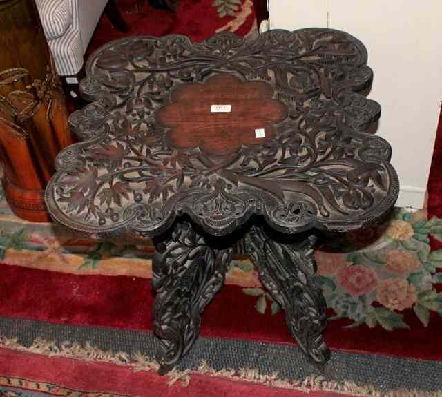 Appraisal: AN ORIENTAL HARDWOOD OCCASIONAL TABLE with heavily carved floral decoration