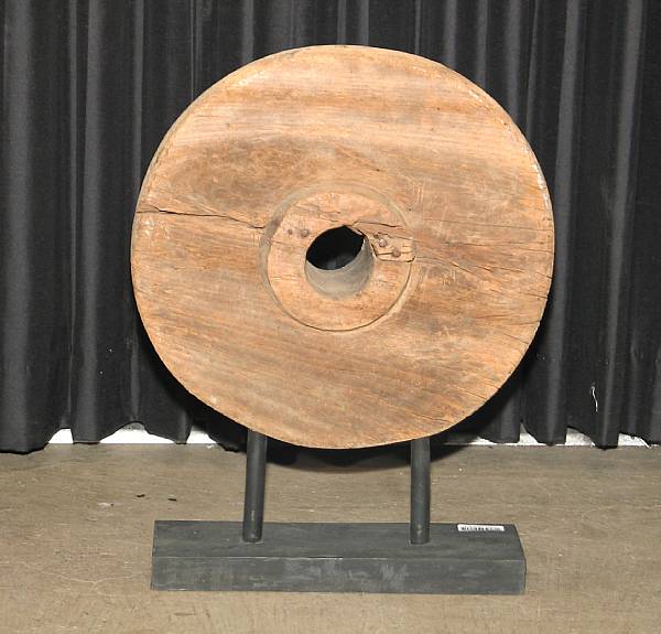 Appraisal: An Asian wooden wheel Raised on a black painted wood